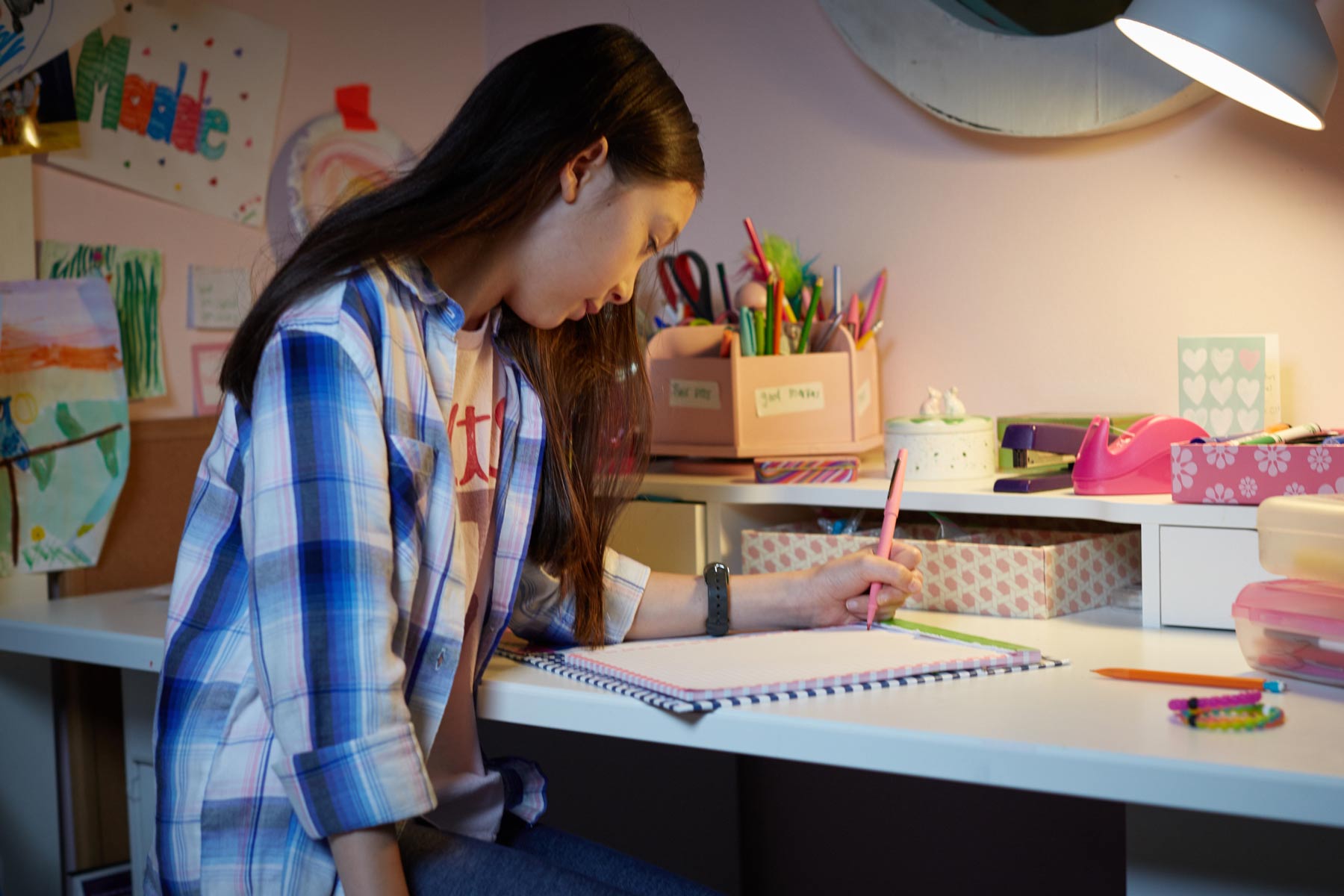 girl doing homework in bedroom
